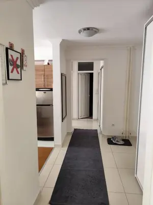 a hallway with white walls and a black carpet at Apartment Stari Grad Korzo Tuzla in Tuzla