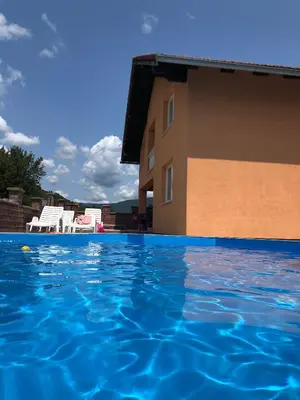 a swimming pool in front of a building at Villa Kula Bihac in Orašac