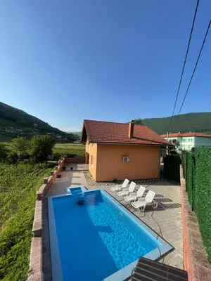 a swimming pool in front of a house at Villa Kula Bihac in Orašac