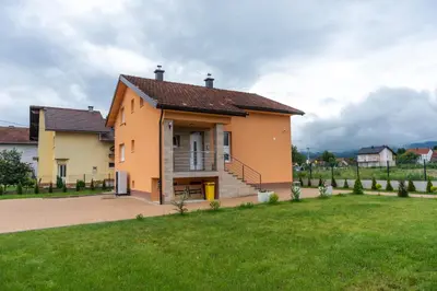 a house with a green lawn in front of it at Casa Lumi in Bugojno