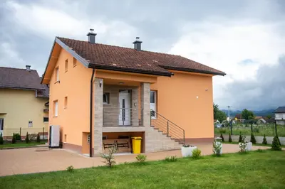 a small house with a staircase in a yard at Casa Lumi in Bugojno