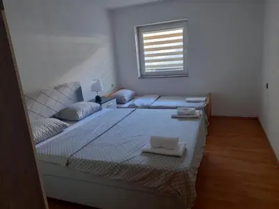 a white bedroom with a bed and a couch at Apartman Zoran in Livno