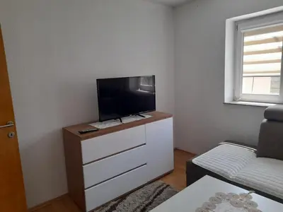 a living room with a flat screen tv on a dresser at Apartman Zoran in Livno