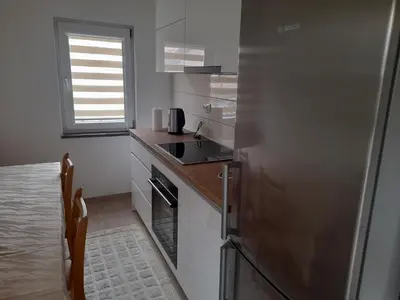 a kitchen with a stainless steel refrigerator and a window at Apartman Zoran in Livno