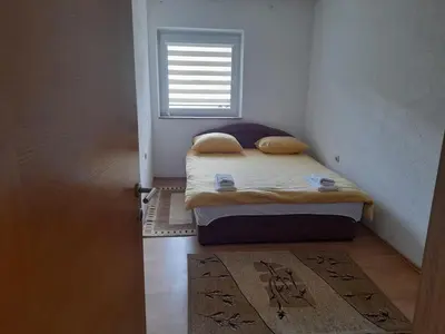 a small bedroom with a bed and a window at Apartman Zoran in Livno