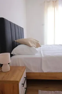 a bedroom with a large white bed with a wooden table at Villa Crystal in Bihać