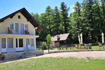 a white house with a porch and a yard at Vikendica Gajić in Šipovo
