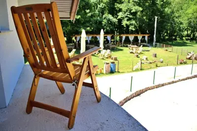 a wooden rocking chair sitting on top of a porch at Vikendica Gajić in Šipovo