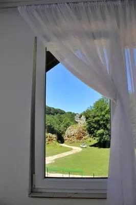 a window with a view of a green field at Vikendica Gajić in Šipovo