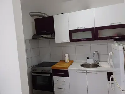 a kitchen with white cabinets and a sink at Zen3 Studio app in Bihać