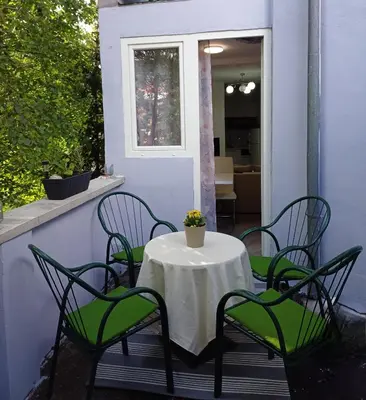 a table with four chairs and a white table cloth on a patio at Zen3 Studio app in Bihać