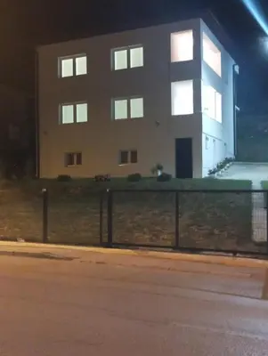 a building at night with a fence in front of it at Apartmani Mušinbegović in Visoko