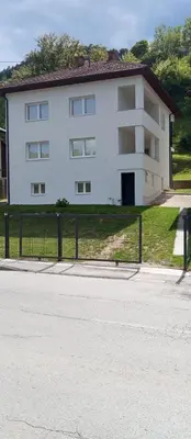 a white building with a fence in front of it at Apartmani Mušinbegović in Visoko
