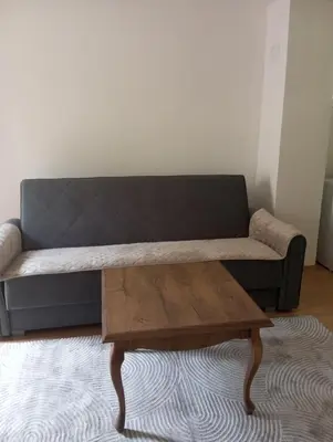 a living room with a couch and a wooden coffee table at Apartmani Mušinbegović in Visoko