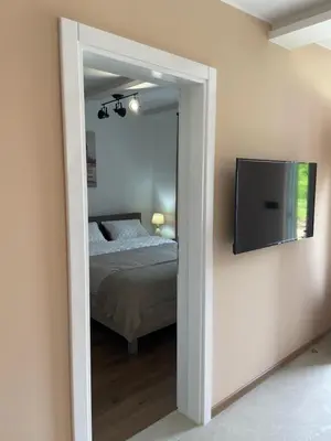 a bedroom with a bed and a flat screen tv at Bungalovi Izvor Plive in Šipovo