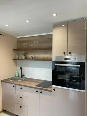 a kitchen with white cabinets and a black oven at Bungalovi Izvor Plive in Šipovo