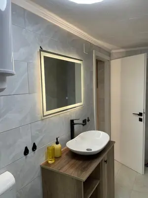 a bathroom with a white sink and a mirror at Bungalovi Izvor Plive in Šipovo