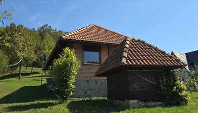 a small brick house with a window in a yard at Villa Enigma in Bihać