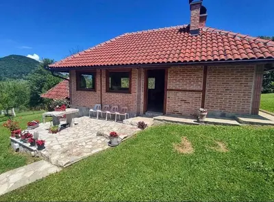 a brick house with a table and chairs in a yard at Villa Enigma in Bihać