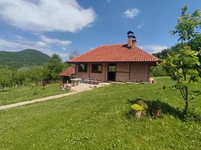 a small house with a red roof in a field at Villa Enigma in Bihać