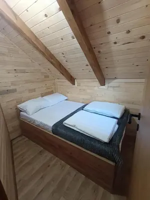 a bedroom with a bed in a wooden cabin at Vikendica Ana in Šipovo