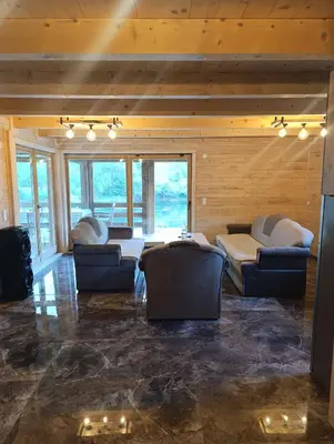 a living room with couches and tables and windows at Vikendica Ana in Šipovo