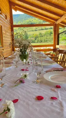 a long table with wine glasses and flowers on it at Vikendica Ana in Šipovo
