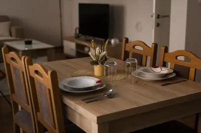 a wooden table with plates and utensils on it at Apartman Dream in Livno