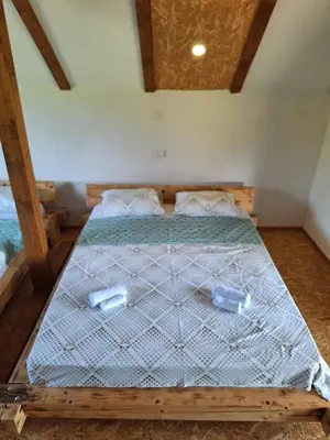 a bedroom with a wooden bed with two containers on it at GREEN MOON Breza in Breza