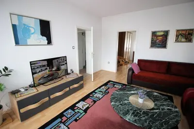 a living room with a red couch and a tv at Apartman Mak in Bihać