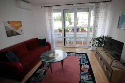 a living room with a red couch and a table at Apartman Mak in Bihać