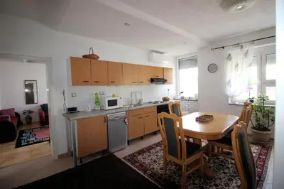 a kitchen and dining room with a table and a table and chairs at Apartman Mak in Bihać