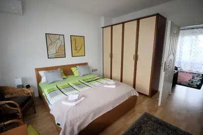 a bedroom with a large bed and a cupboard at Apartman Mak in Bihać