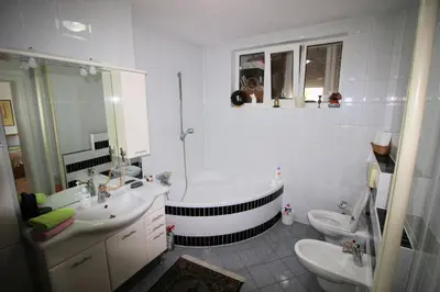 a bathroom with a tub and two sinks and a toilet at Apartman Mak in Bihać