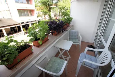 a balcony with chairs and plants on a building at Apartman Mak in Bihać