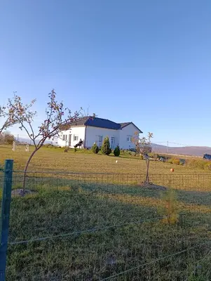 a fence in front of a field with a house at Vila Anamari in Livno