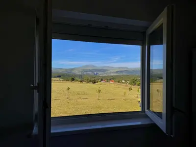 an open window with a view of a field at Vila Anamari in Livno