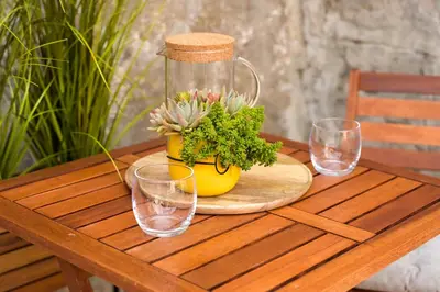 a wooden table with a flower pot and glasses on it at ZenDen in Jajce