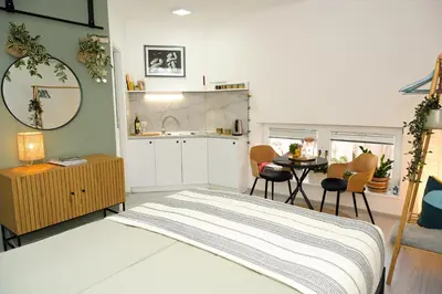 a bedroom with a bed and a table and a kitchen at ZenDen in Jajce