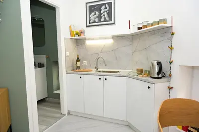 a kitchen with white cabinets and a sink at ZenDen in Jajce