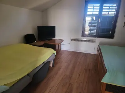 a room with two beds and a desk with a computer at VIKENDICA GARFILD SA BAZENOM i SAUNOM BANJA LUKA in Banja Luka