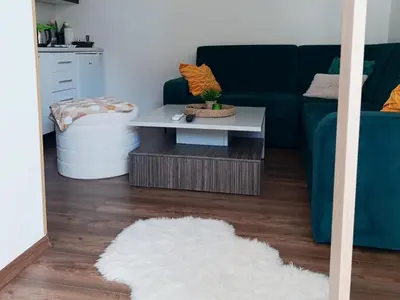 a living room with a blue couch and a table at Apartman EDEN in Jajce