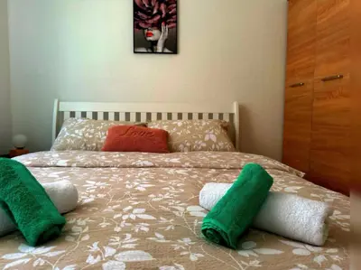 a bed with green and white pillows on it at Apartman EDEN in Jajce