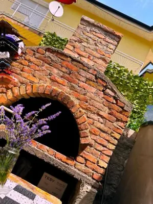 a brick oven in the side of a building with flowers at Apartman EDEN in Jajce