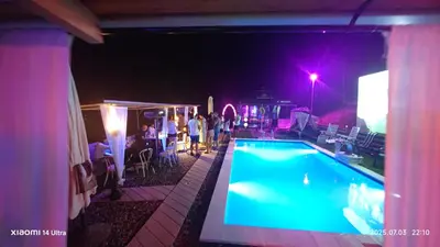a swimming pool at night with people standing around it at Nature Neno in Visoko