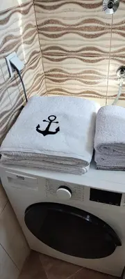 a washing machine with towels on top of it at Apartman IDEA Tuzla in Tuzla