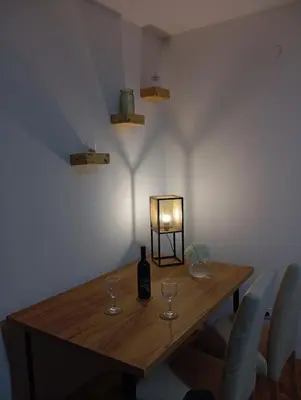 a table with a bottle of wine and glasses on it at The Orchid in Jajce