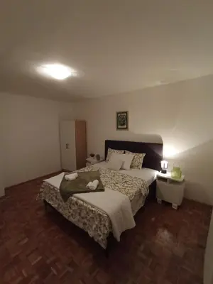 a bedroom with a large bed and a night stand at The Orchid in Jajce
