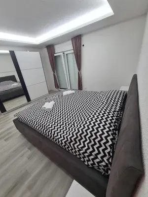 a bedroom with a bed with a black and white comforter at Apartman Dani in Jajce