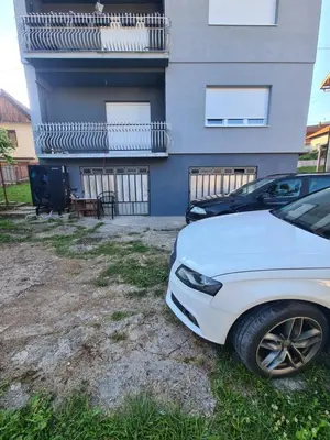 a white car parked in front of a building at Apartman Dani in Jajce
